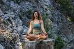 woman in blue spaghetti strap top sitting on brown wooden log